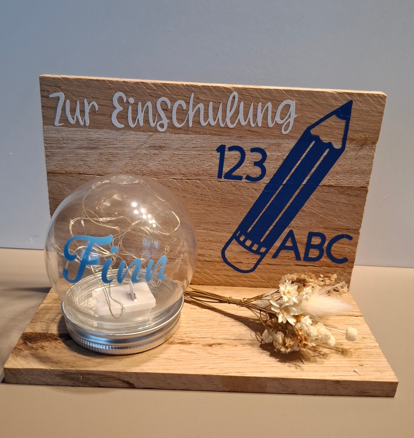 Klötzchenwand mit Blumen und Leuchtkugel "Zur Einschulung"