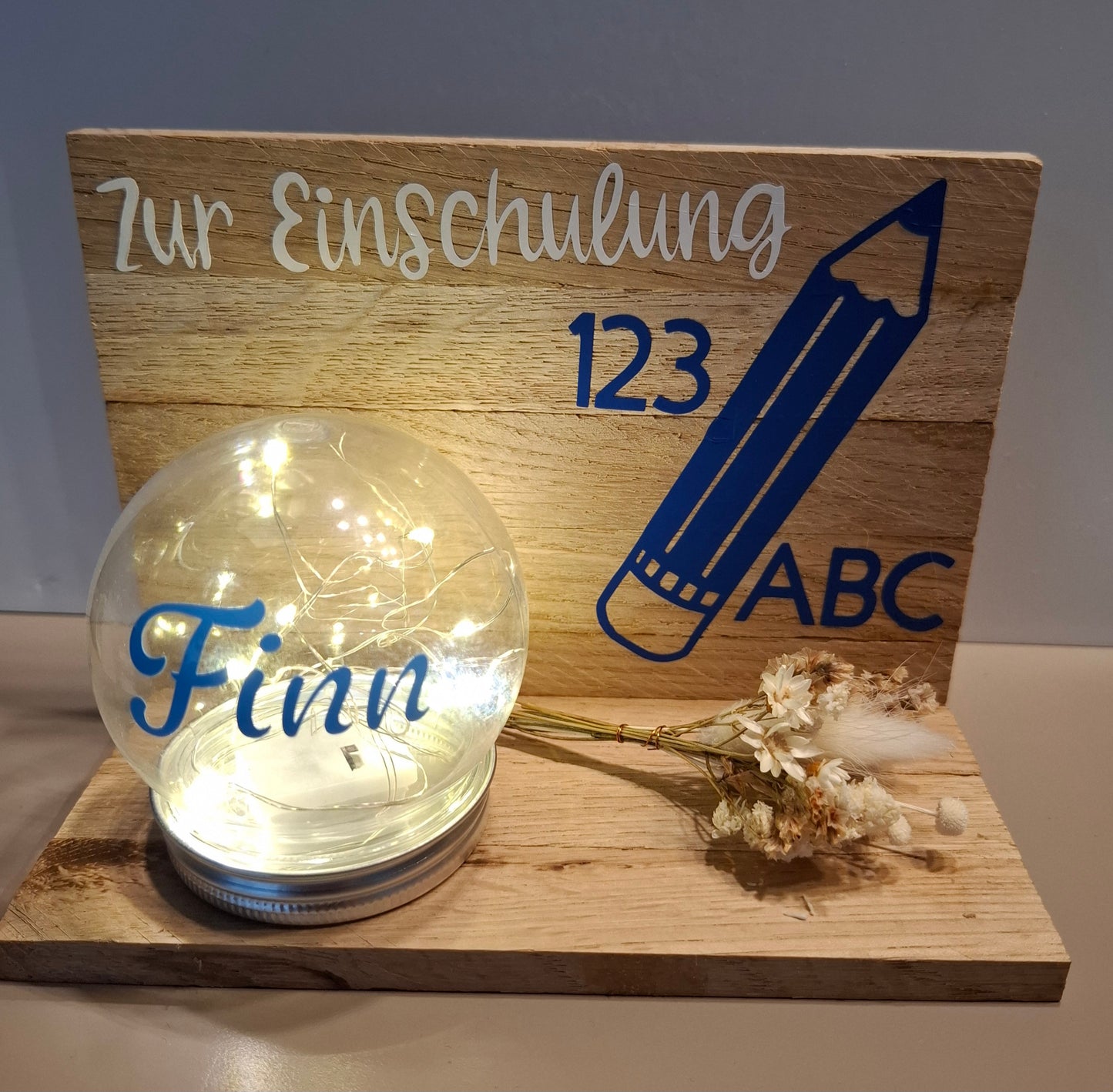 Klötzchenwand mit Blumen und Leuchtkugel "Zur Einschulung"
