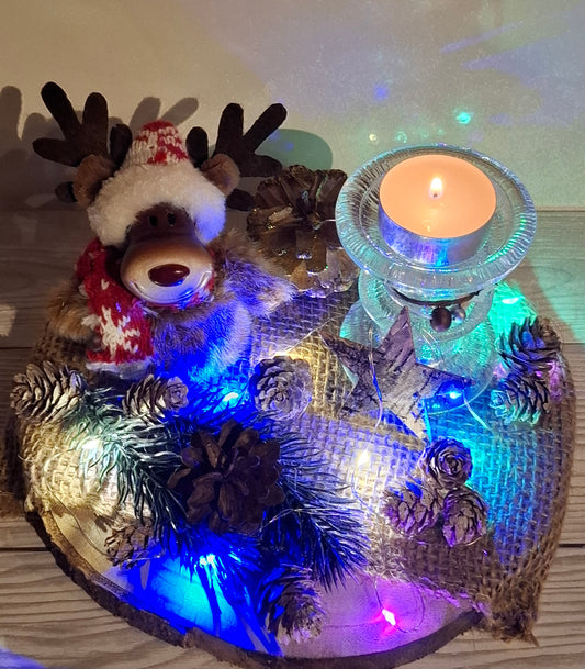 Zuckersüßer Elch auf Holztablett mit Kerzenständer und Lichterkette