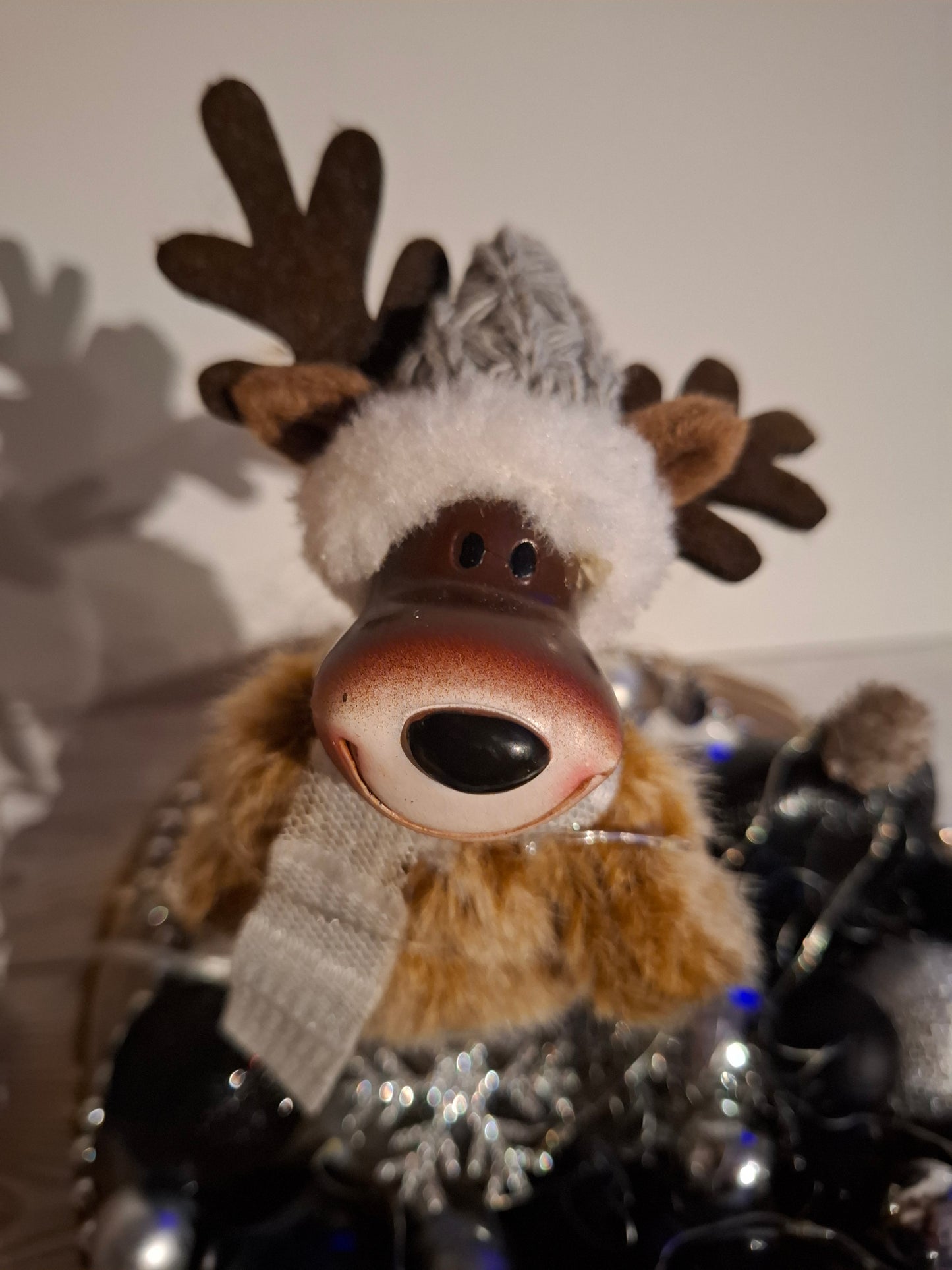 Zuckersüßer Elch in einer Holzschale mit Lichterkette