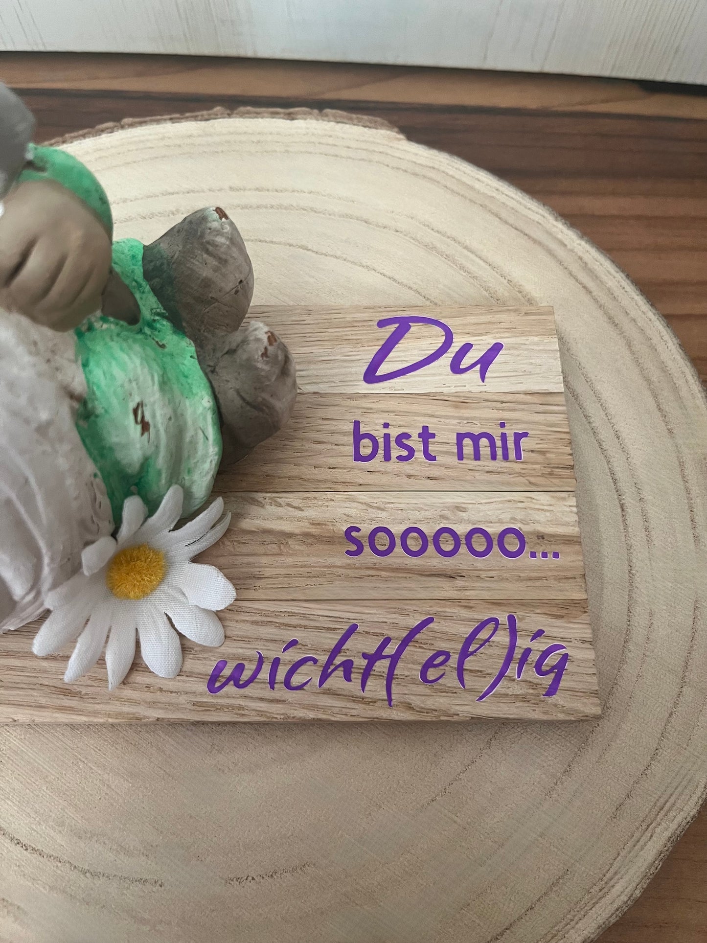 Sitzender Wichtel mit lila Mütze, Klötzchenleiste und Text