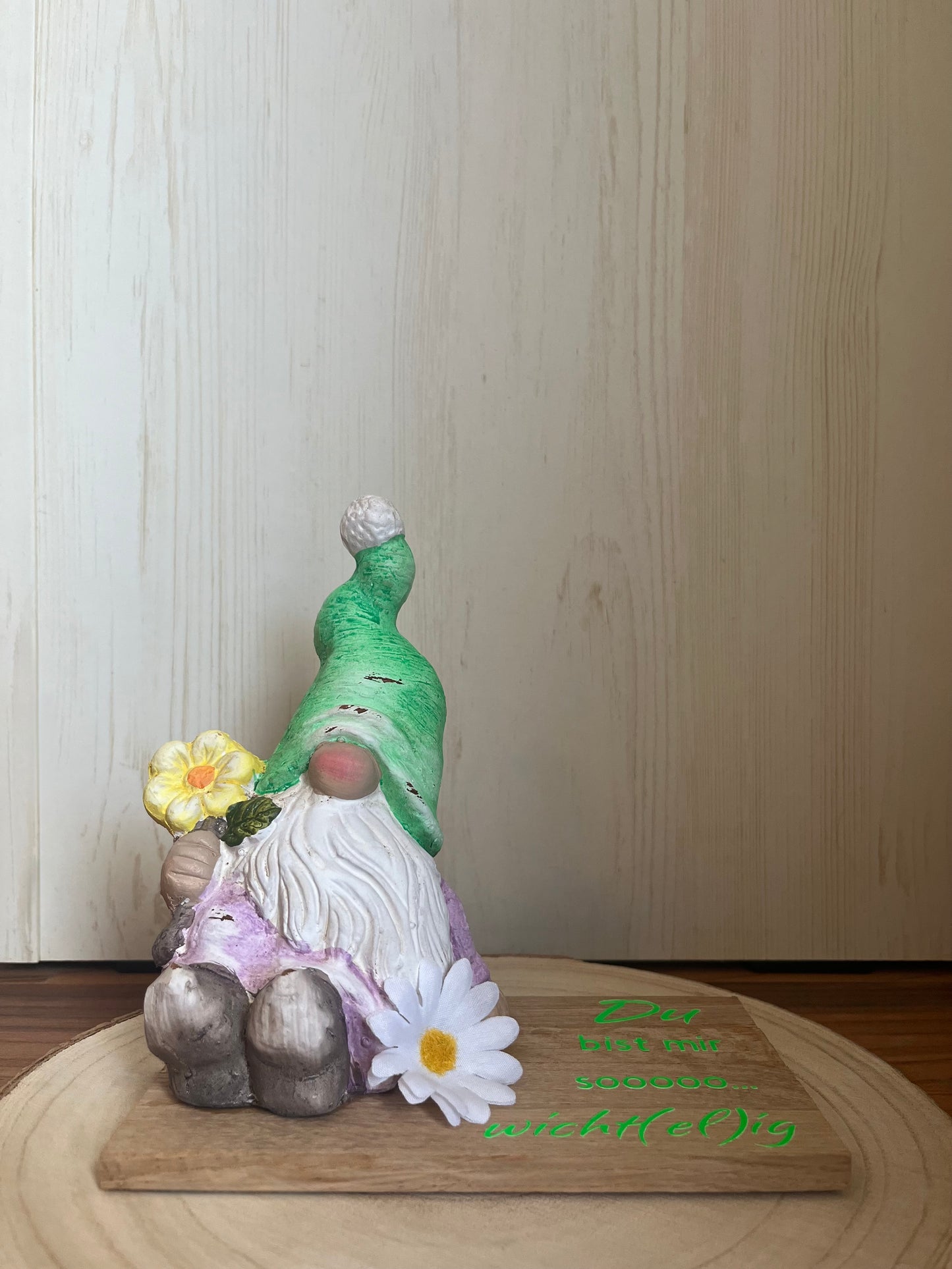Sitzender Wichtel mit grüner Mütze, Klötzchenleiste und Text