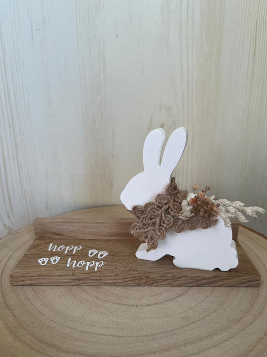 Hase sitzend mit Band, Blumen, Klötzchenleiste und Text